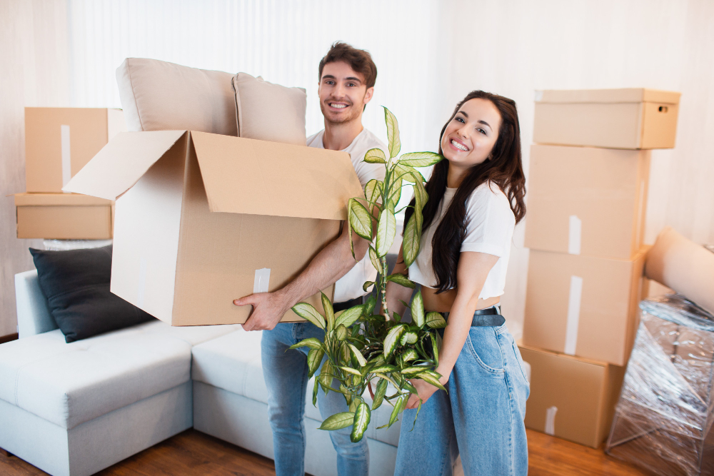 happy-couple-with-cardboard-boxes-in-new-house-at-moving-day